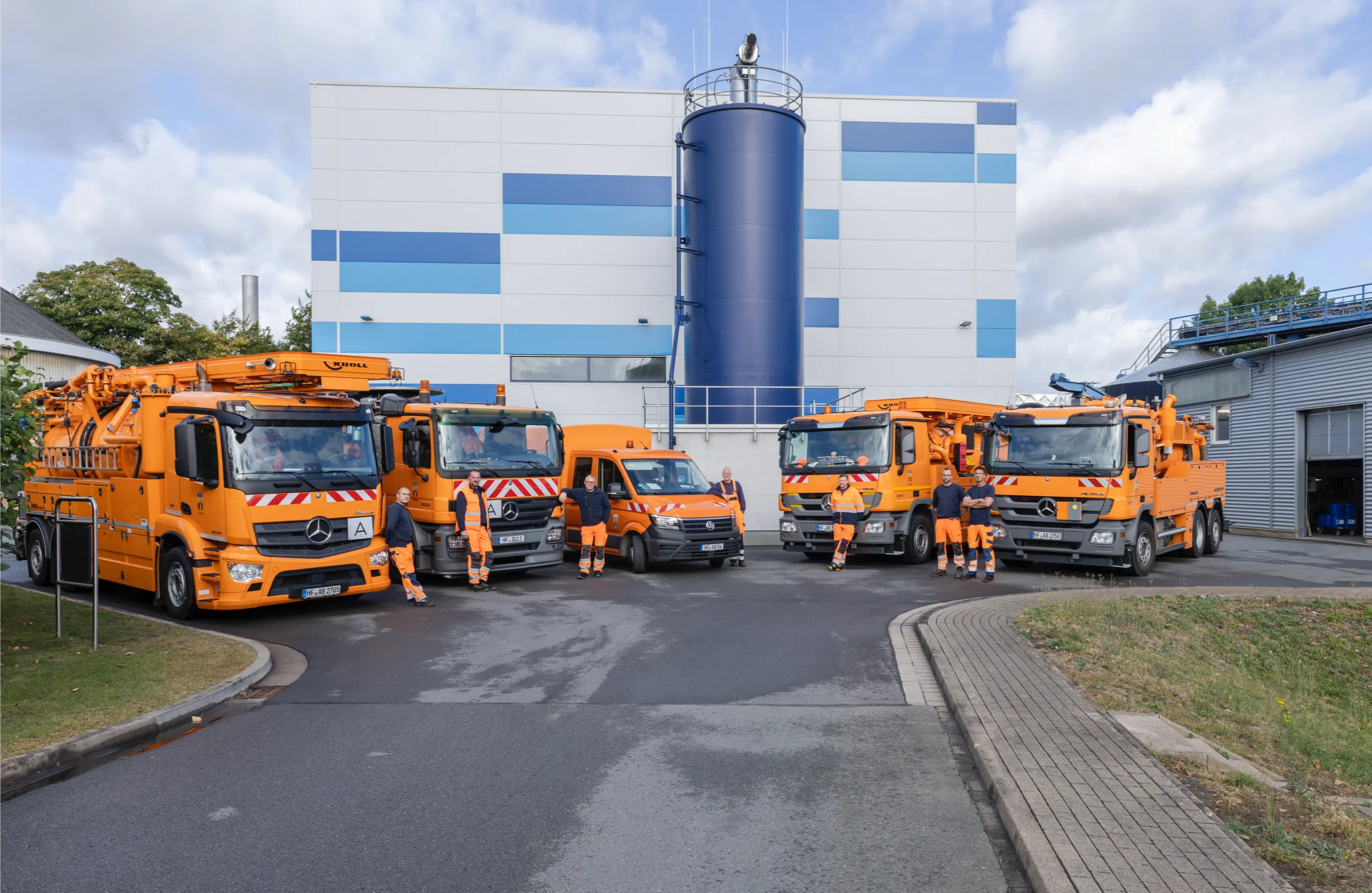 Gruppe von Mitarbeitern vor Abwasserfahrzeugen